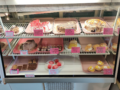 Cakes and desserts with handwritten labels in the display case